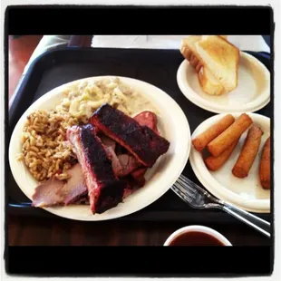 3 meat dinner -  ensalada, toast, ribs, sliced beef, sausage, beef mac n cheese, dirty rice with a side of hush puppies. yum.