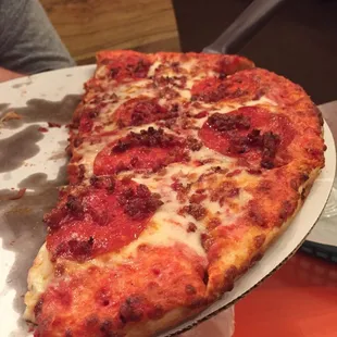 Half of a 13' pizza with pepperoni and bacon.