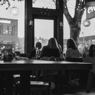 a black and white photo of people sitting at a table