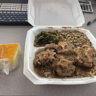 Beef oxtails over rice, mustard greens, black-eyed peas, cornbread