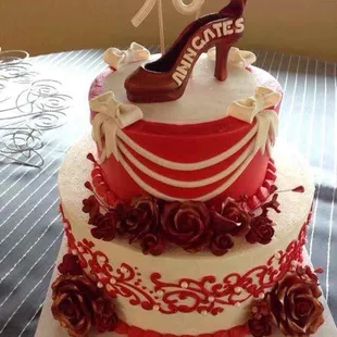 a red and white cake with high heels on top