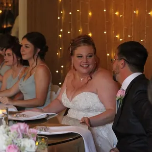 Head table in front of burlap wall with twinkle lights