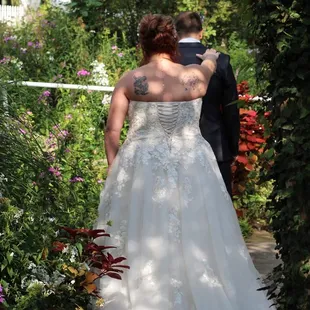 Bride telling groom to turn around in the garden