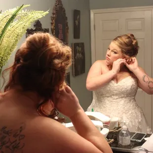 Bride getting ready in the HUGE mirror in the women's restroom
