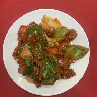 Chicken Chili - Stir fried chicken with onions, peppers, ginger, and garlic blended together in a spicy chili sauce garnished with cilantro.