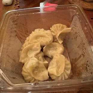 Vegetable momo (dumplings). The packet of spicy sauce and two dumplings already removed.