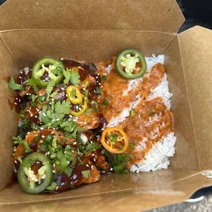 a takeout box with rice, chili, and jalapenos