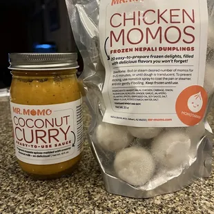 a bag of chicken momos next to a jar of peanut butter