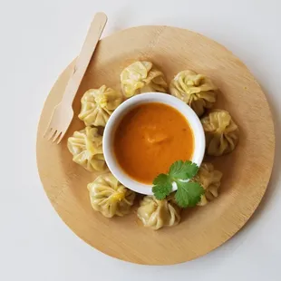 MoMos served in eco-friendly small ware, with House made sauce.