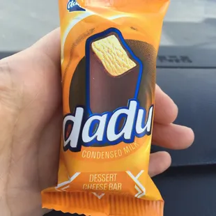 a hand holding a bag of dadu cheese bars