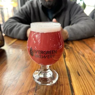 a man sitting at a table with a glass of beer