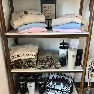 a shelf full of coffee mugs and blankets