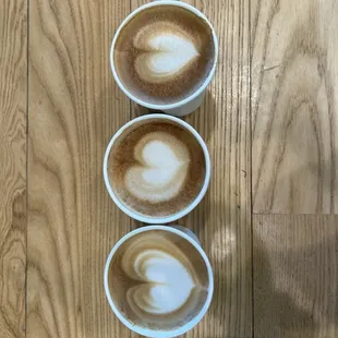 three cups of coffee on a wooden table