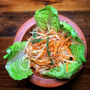 a plate of salad with lettuce and carrots