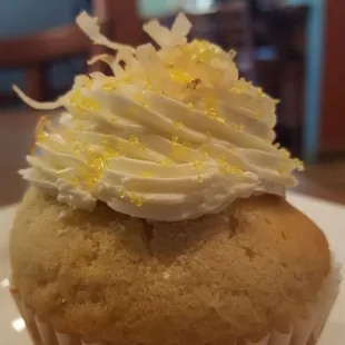 The coconut cream pie cupcake, complete with a coconut cream filling inside, and coconut flakes on top.