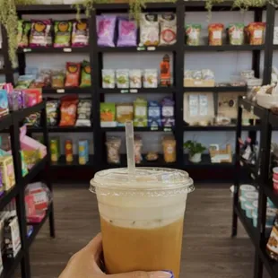 a hand holding a cup of iced coffee