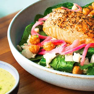 a bowl of salad with salmon and chickpeas