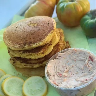 a stack of pancakes and a bowl of dip