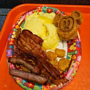 Scrambled eggs, bacon, sausage, hash browns, and a Mickey pancake
