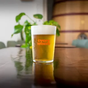 a glass of beer sitting on a table