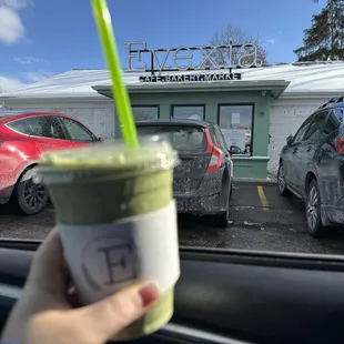  hand holding a cup of green smoothie