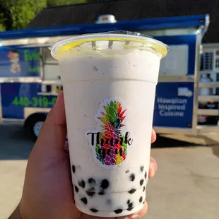 a hand holding a cup of bubble tea