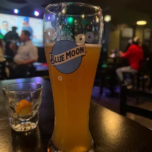 a glass of blue moon beer on a table