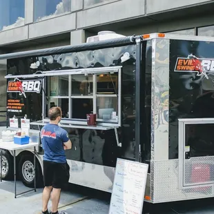 two men standing in front of a food truck