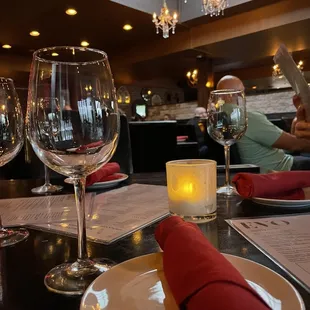 a table setting with wine glasses and napkins