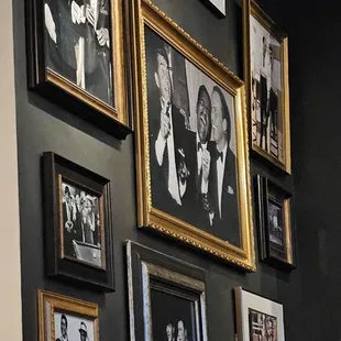 a wall full of framed photos of men