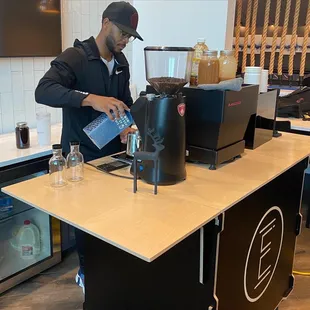 a man pouring coffee into a blender