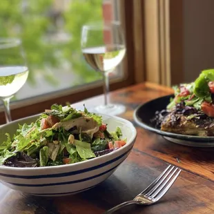 a bowl of salad and a glass of wine