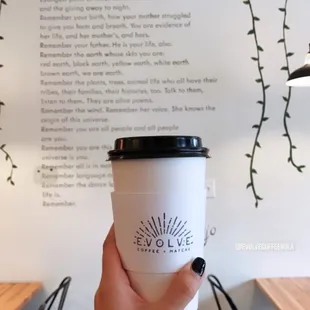 a hand holding a coffee cup