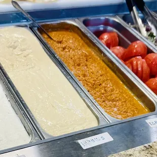 Sauces in order from left to right: Garlic , hummus and spicy sauce  Fresh sliced tomato , onion and lettuce