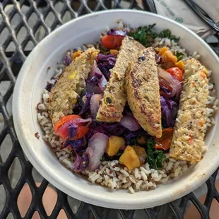 a bowl of rice with chicken and vegetables