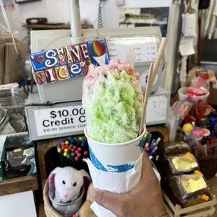 a hand holding a cup of ice cream