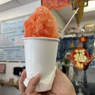 a hand holding a cup of ice cream