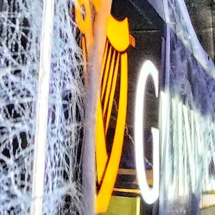 a neon sign with spider webs