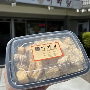 a person holding a plastic container of food