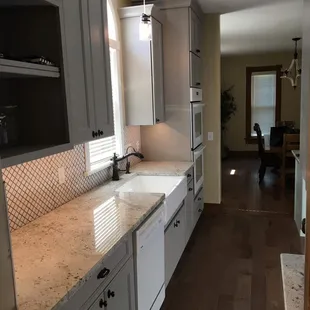 a kitchen with white cabinets and granite countertops