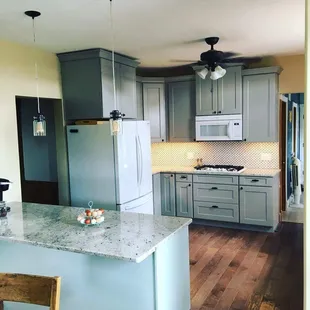 a kitchen with gray cabinets and white appliances