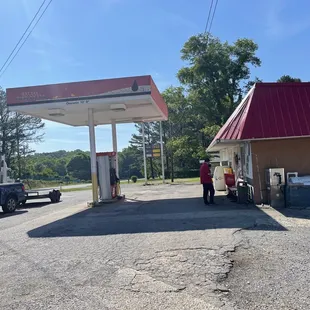 ows a man filling up his car at a gas station