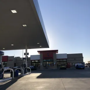 a gas station with cars parked in front of it