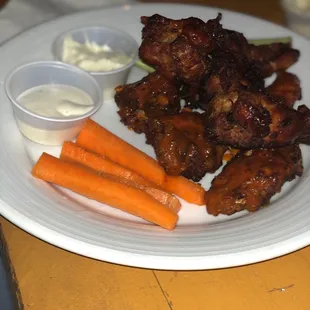 a plate of chicken wings and carrots