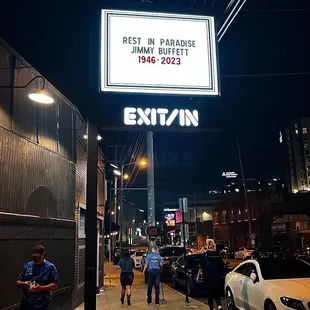 people walking down a city street at night