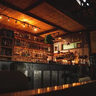 a dimly lit bar with a lot of bottles