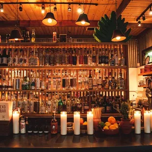 a bar with candles and bottles of alcohol
