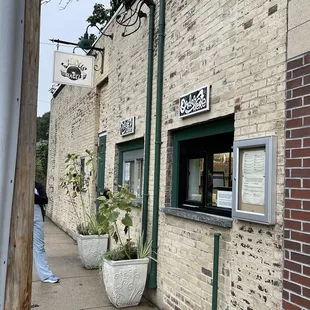 a man walking past a brick building