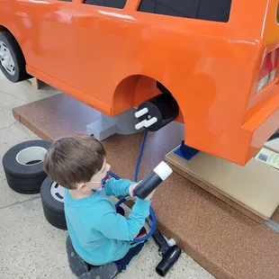 Changing the tire on a car at Explore Children's Museum
