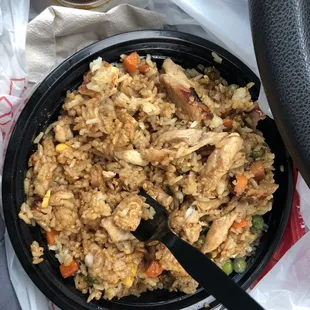 Rice bowl with chicken added after terayaki sauce and packet of soy sauce added